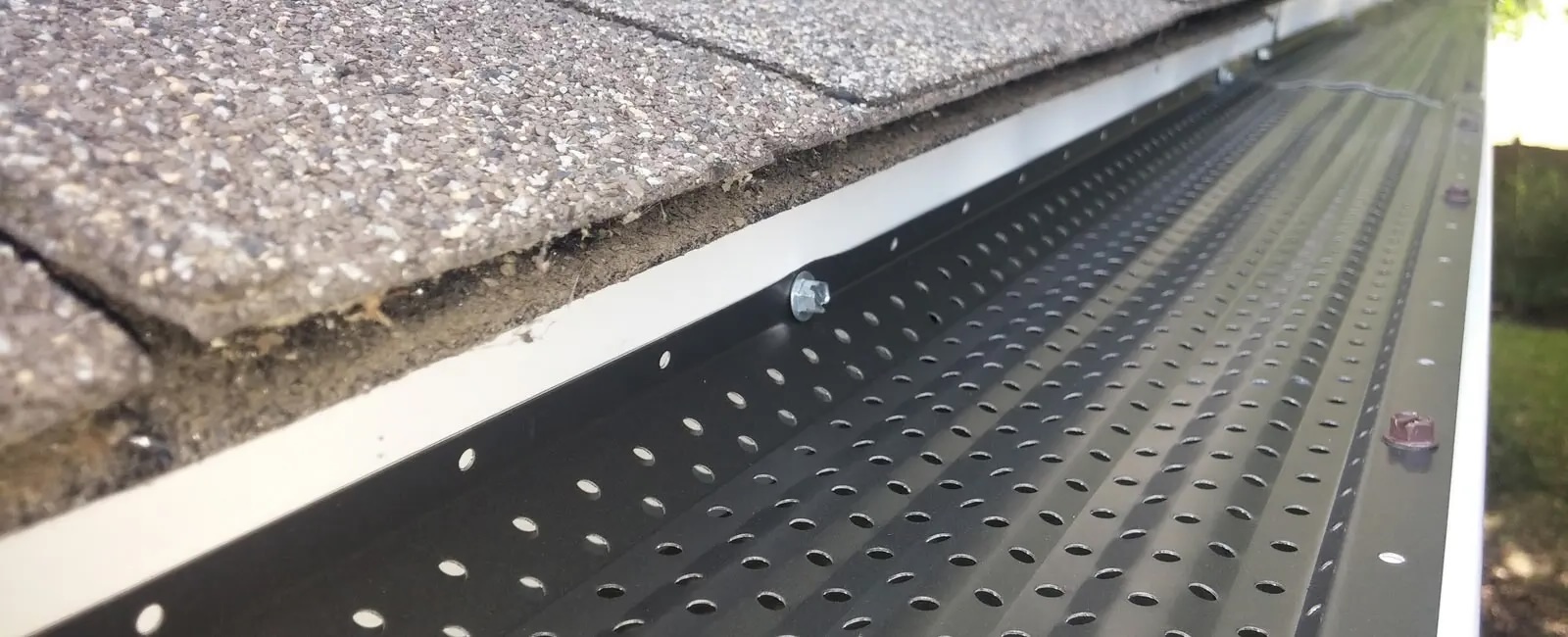 Snow and ice buildup on a roofline with gutter guards installed