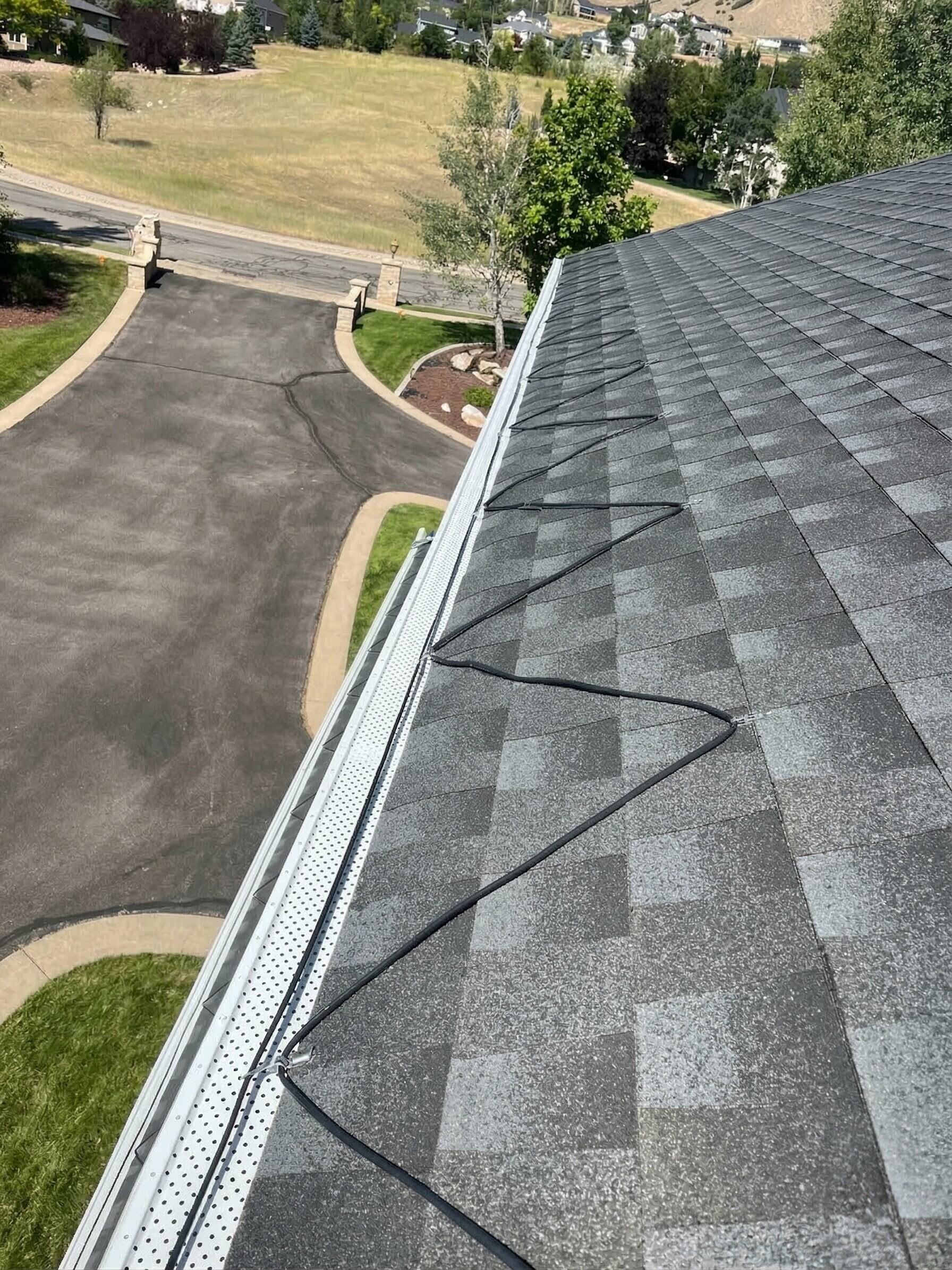 Heat tape cable installed on top of gutter guard mesh